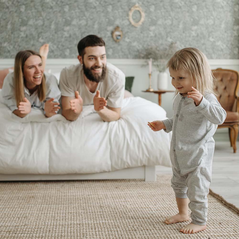 Parents cheerfully clapping encouraging the child to express their thoughts