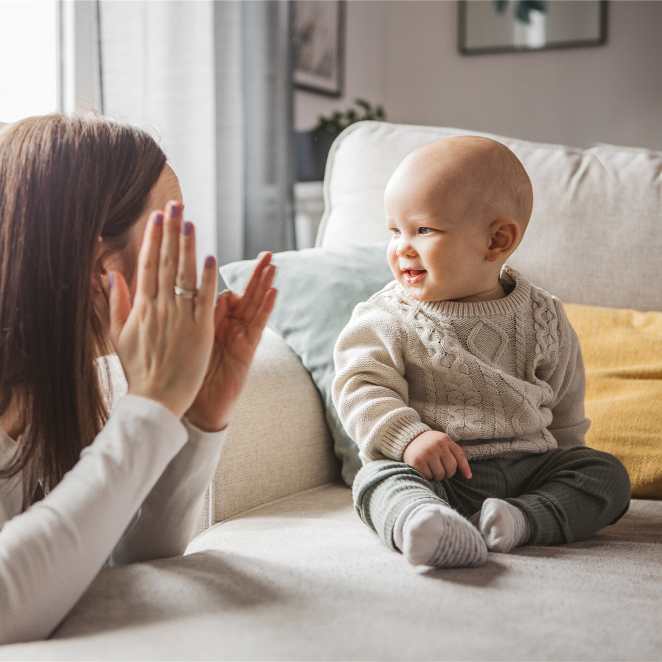 A mother is teaching baby with sign language