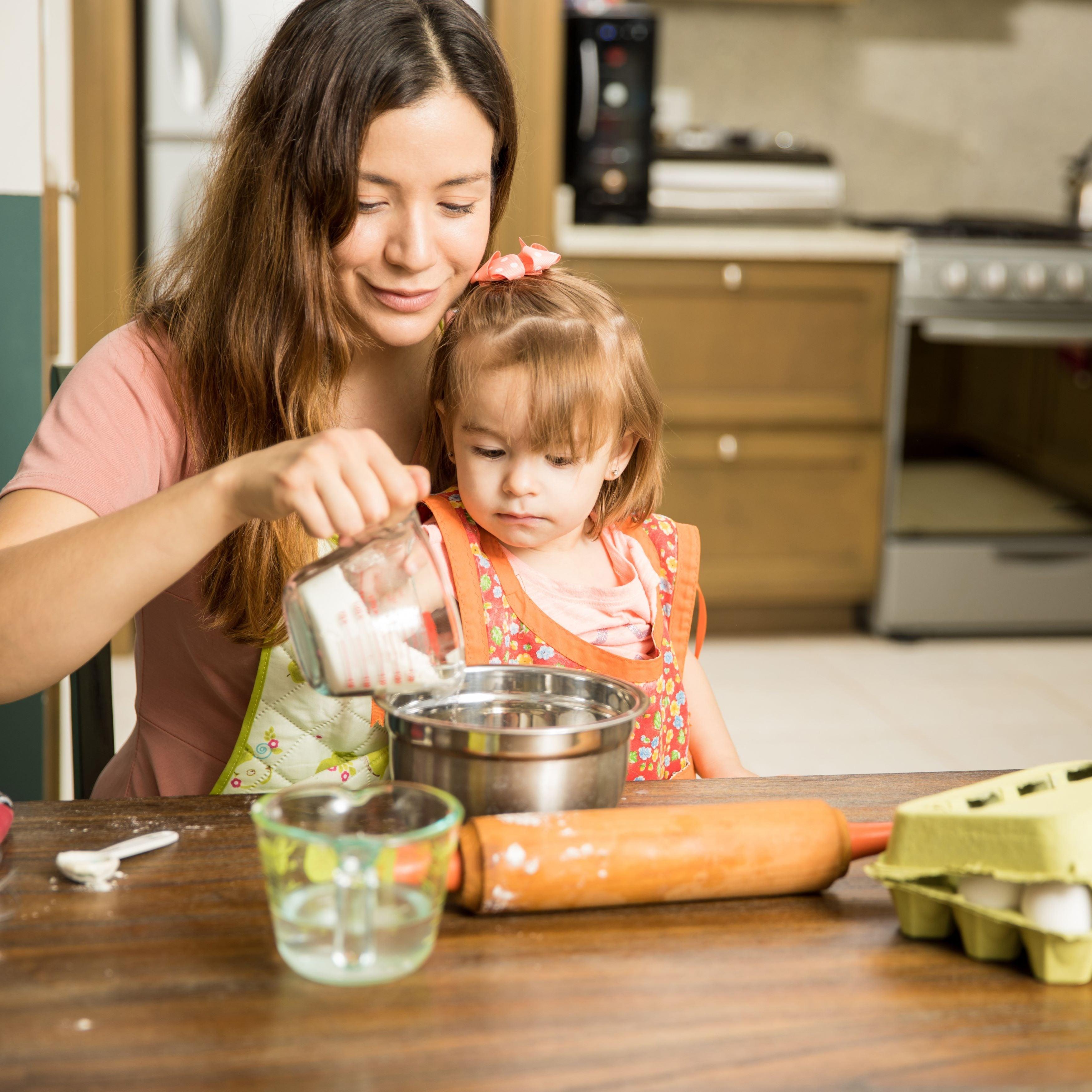 Mom and daughter are preparing dough in the kitchen