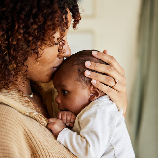 Mother kissing with her baby boy in her arms