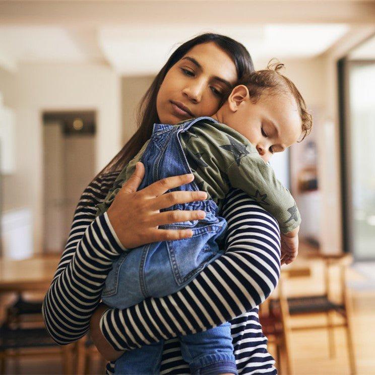 The mother, her face full of concern, is holding her sick child close.