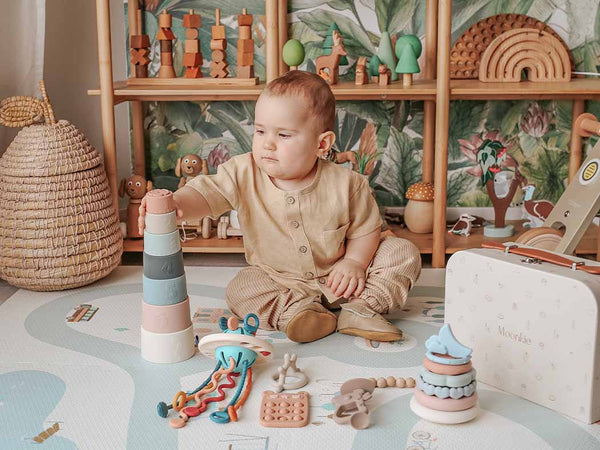 Child playing with toys in a room filled with wooden and natural materials