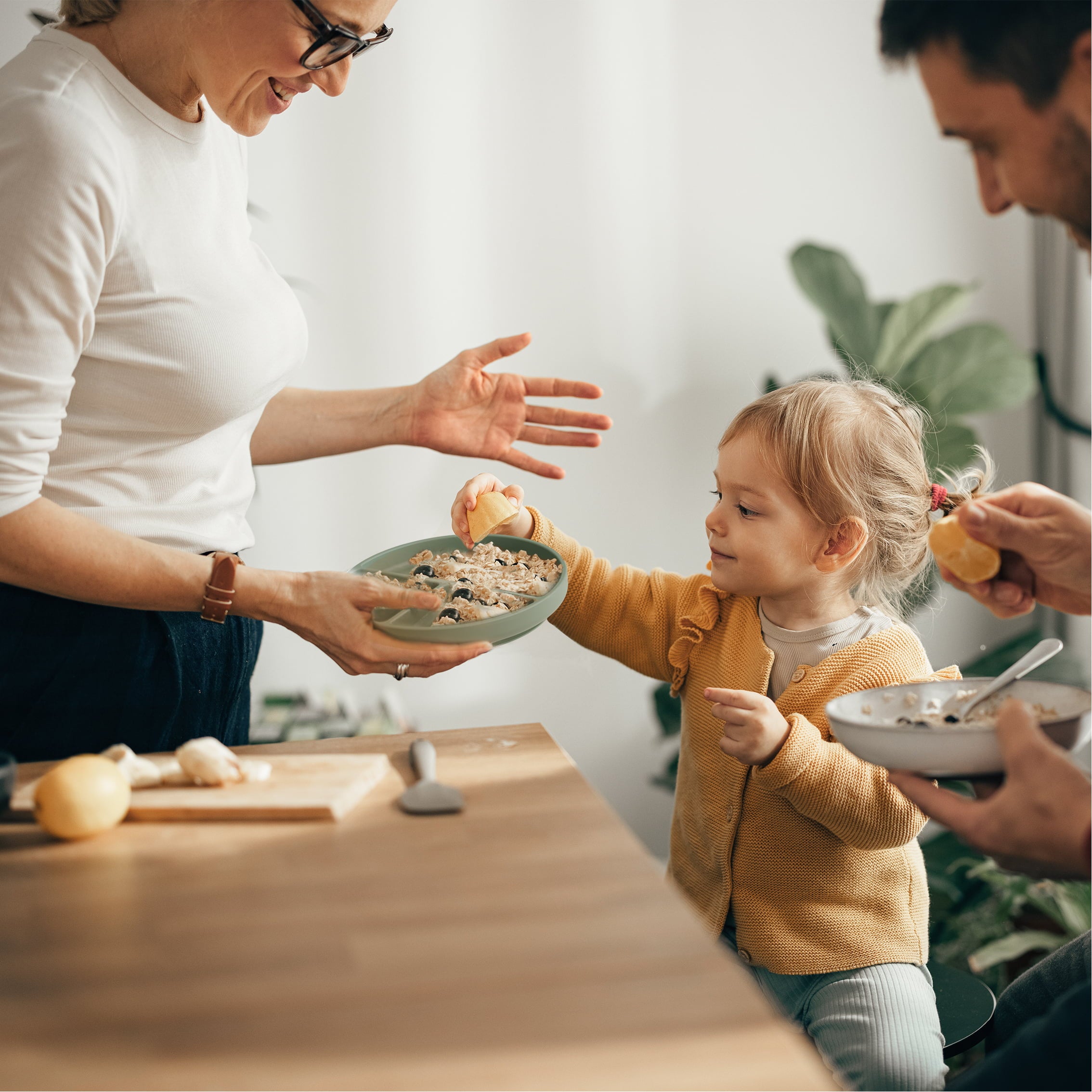 Mom is feeding her baby with the Plate From First Bites Gift Set